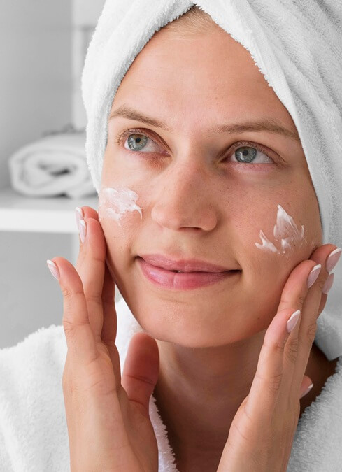 close up woman using facial cream 1