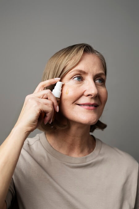 medium shot smiley woman using serum 1