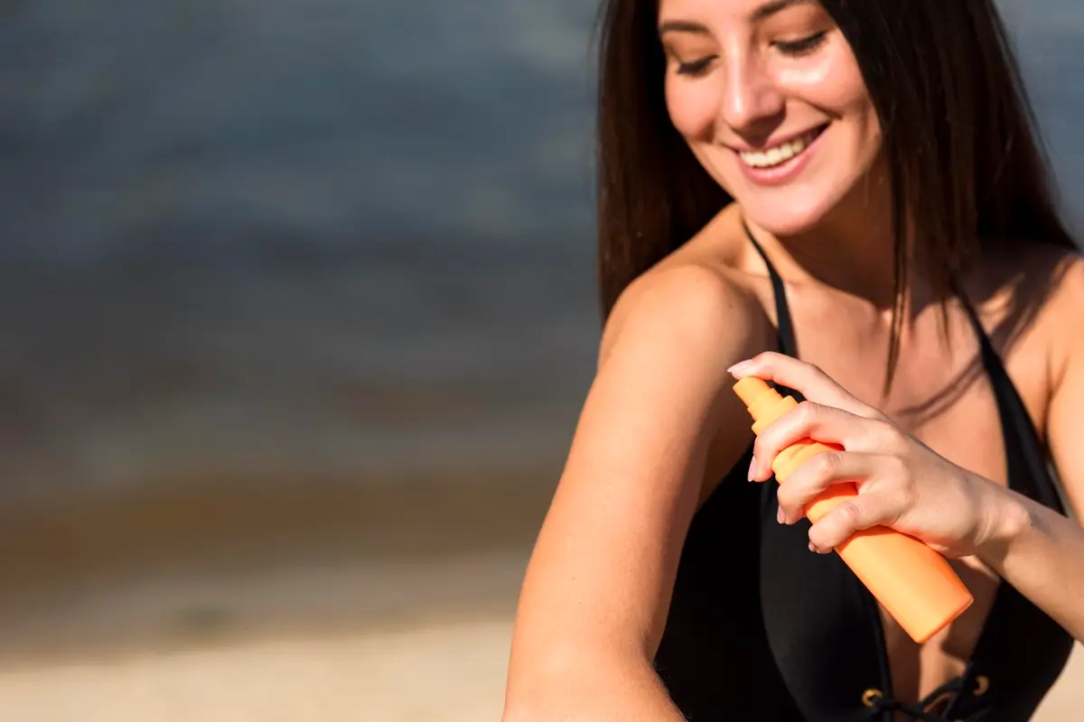 smiley woman applying sunscreen beach